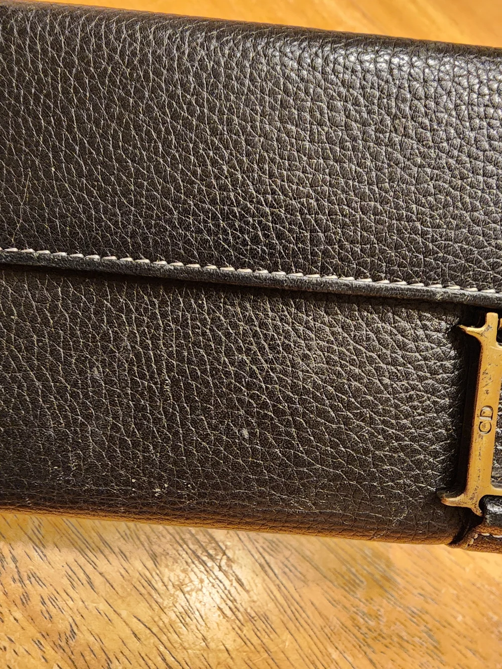 black Christian Dior pebbled leather trifold long wallet featuring gold-tone 
